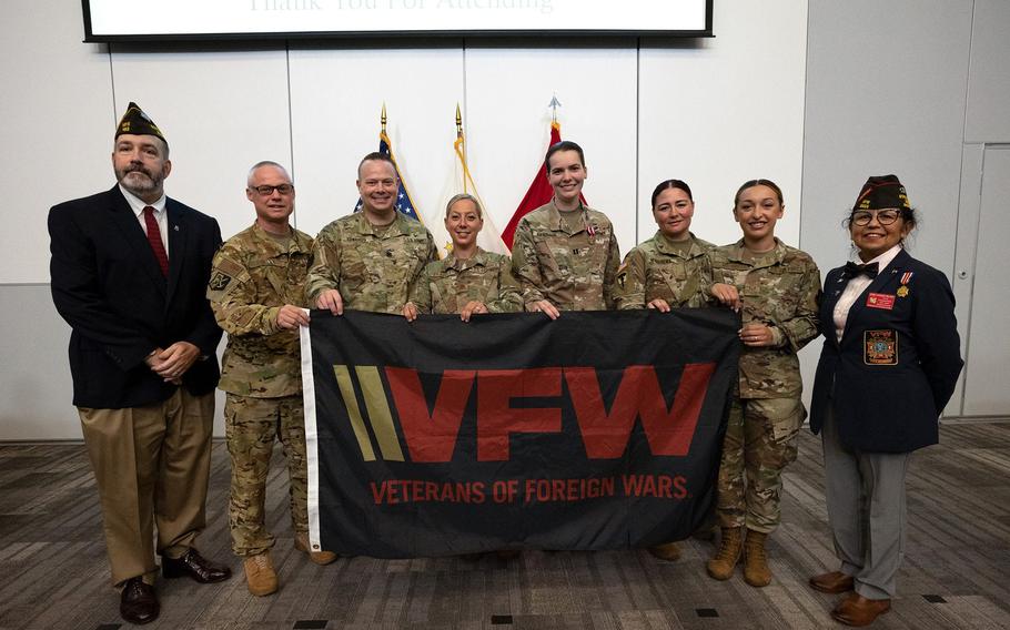 Matthew McCoy, left, state adjutant for the Rhode Island Veterans of Foreign Wars, stands alongside Col. David Ashley, Lt. Col. Matthew Edwards, Maj. Joanne Barrett, Capt. Regan Keenan, Staff Sgt. Jessica Godena, Staff Sgt. Nicole Mackay and Dora Vasquez-Hellner, state commander for the Rhode Island Veterans of Foreign Wars, during an award ceremony at Camp Fogarty on Wednesday.