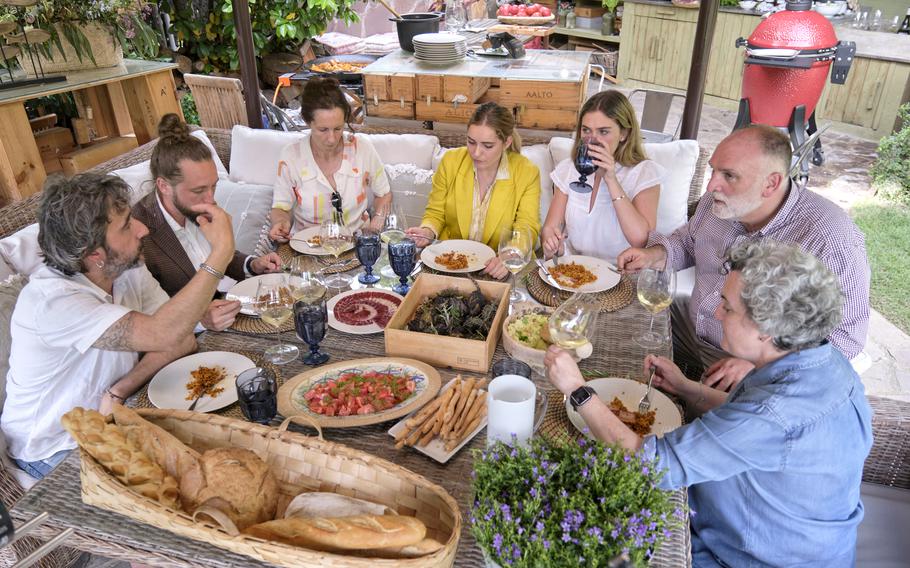 José Andrés, second from right, and family dine with friends at Pepe Muñoz (right)’s house in a scene from the Discovery+ television series “José Andrés and Family in Spain.” 
