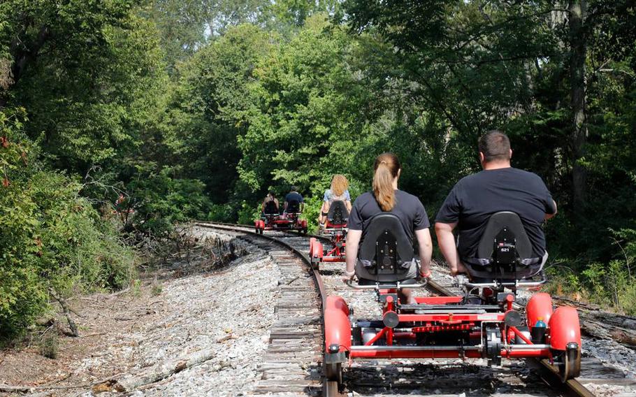Visitors on the Rail Explorers rail bike pedal over train tracks in Versailles, Ky., from the Bluegrass Scenic Railroad and Museum. 