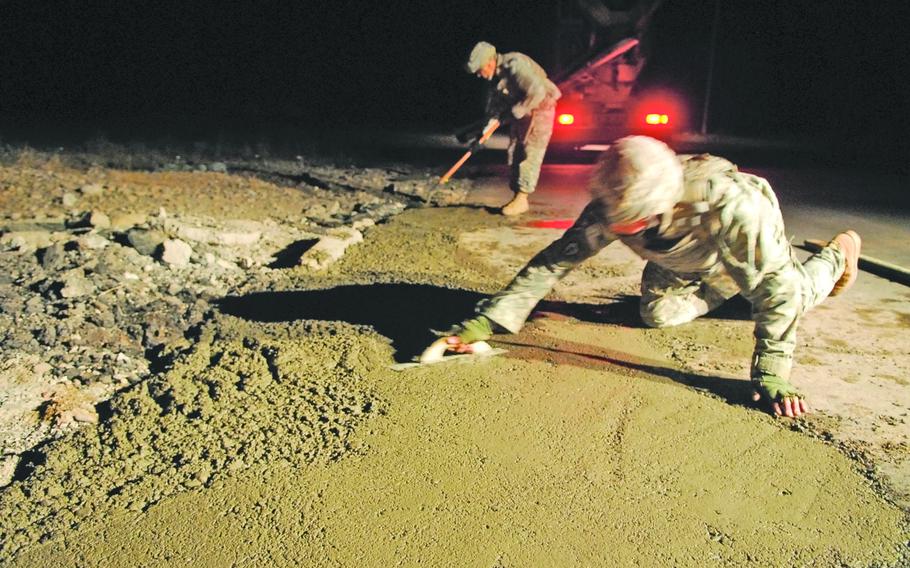Soldiers with the 19th Engineer Battalion smooth concrete after filling roadside bomb craters along a main highway near Tikrit.