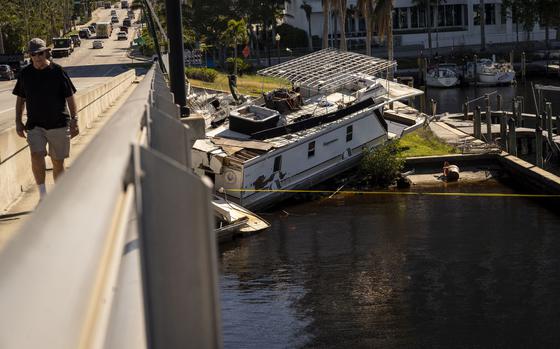 Damaged boats sit next to a bridge in Fort Myers, Fla., on Jan. 12. Months after Hurricane Ian laid waste to communities in the area, volunteers and officials are still finding bodies in sunken sailboats and tangled mangroves. MUST CREDIT: Photo for The Washington Post by Thomas Simonetti