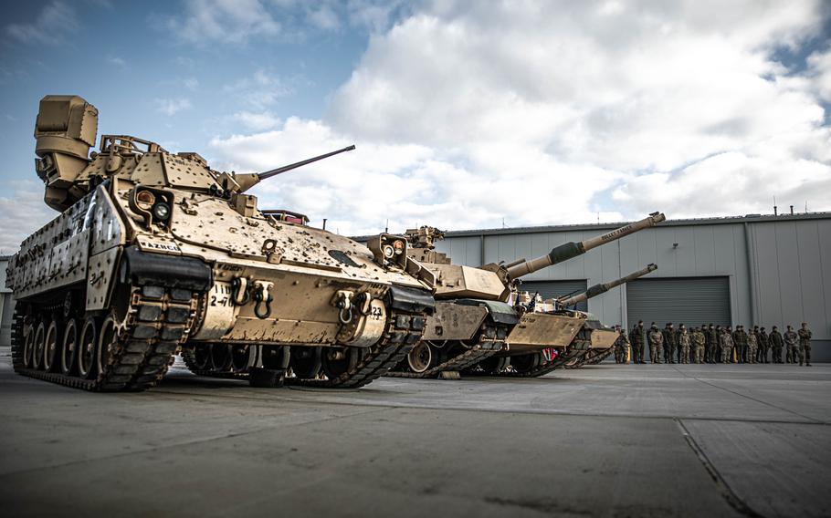 An M2A3 Bradley Fighting Vehicle and Abrams tanks are on display during the opening ceremony for the Army's new weapons depot in Powidz, Poland, on April 5, 2023.