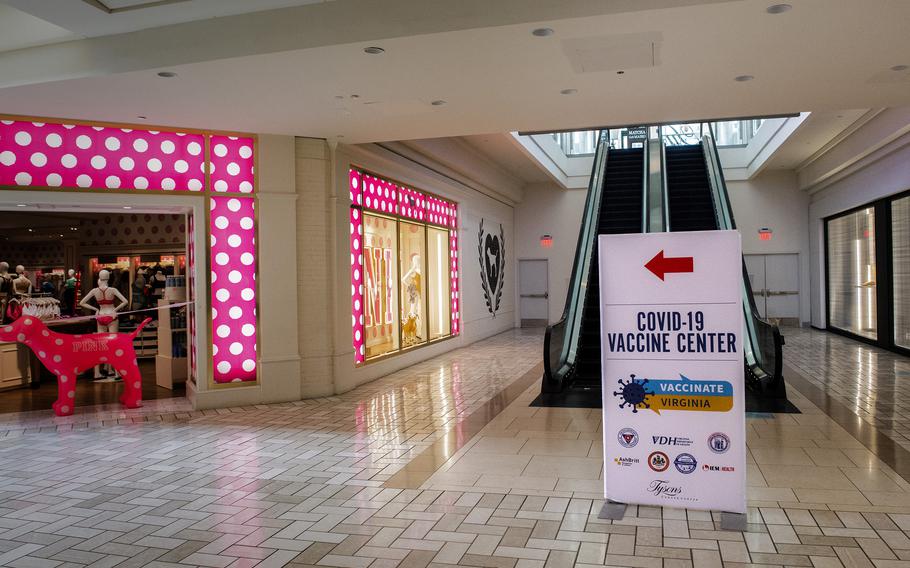 Signs in a shopping mall direct citizens to community vaccination center, housed in an old department store, in Tysons Corner, Va. 