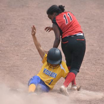 Wiesbaden’s Olivia Office slides into third, trying to get past Kaiserslautern’s Selam Foery in a first-round game Thursday, May 19, 2022, in the DODEA -urope softball tournament at Ramstein Air Base, Germany. Wiesbaden went on to win, 16-5.