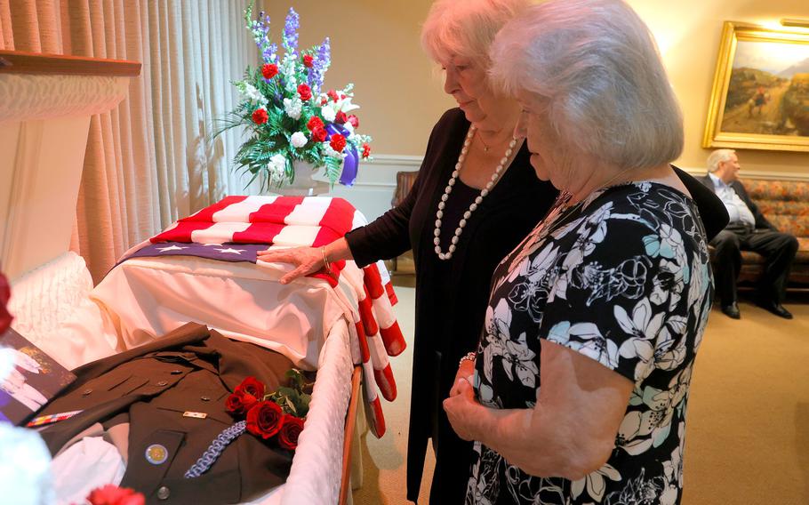 Patricia Ozybko, middle, and Helen Hoogacker-Fennell, sisters of U.S. Army Pfc.  Phillip Hoogacker, talk about him while viewing his Army uniform and pictures in his casket before the funeral service for Phillip Hoogacker at R.G. & G.R. Harris Funeral Home in Livonia, Mich., on July 23, 2021.