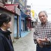 Seiji Tokutomi talks to a student about Koza's history in Okinawa City, Okinawa Prefecture, in March. MUST CREDIT: Japan News-Yomiuri.