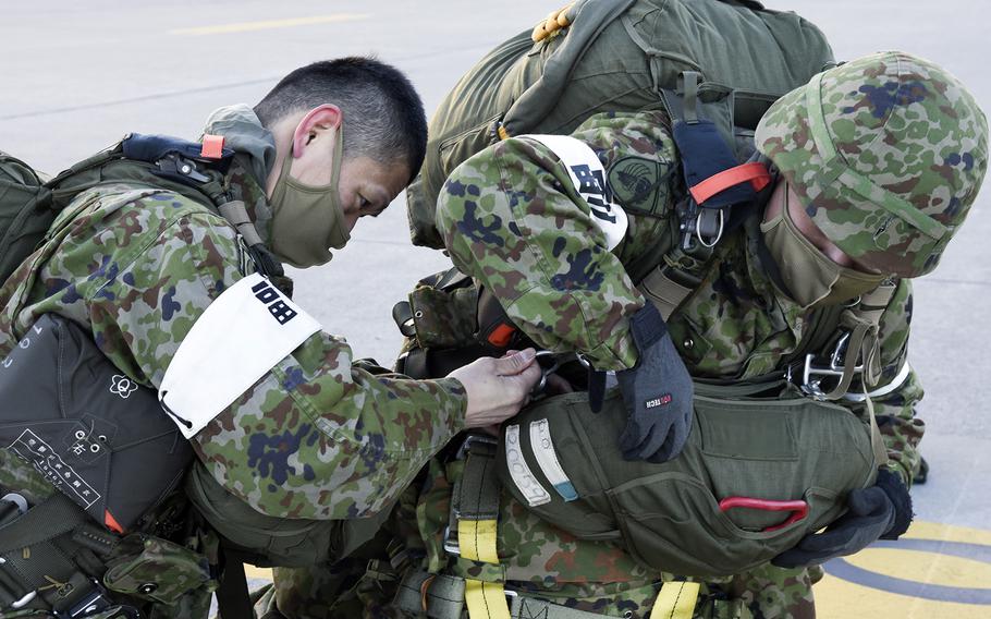 Paratroopers from the Japan Ground Self-Defense Force prepare their gear at Yokota Air Base, Japan, Tuesday, Jan. 31, 2023. 