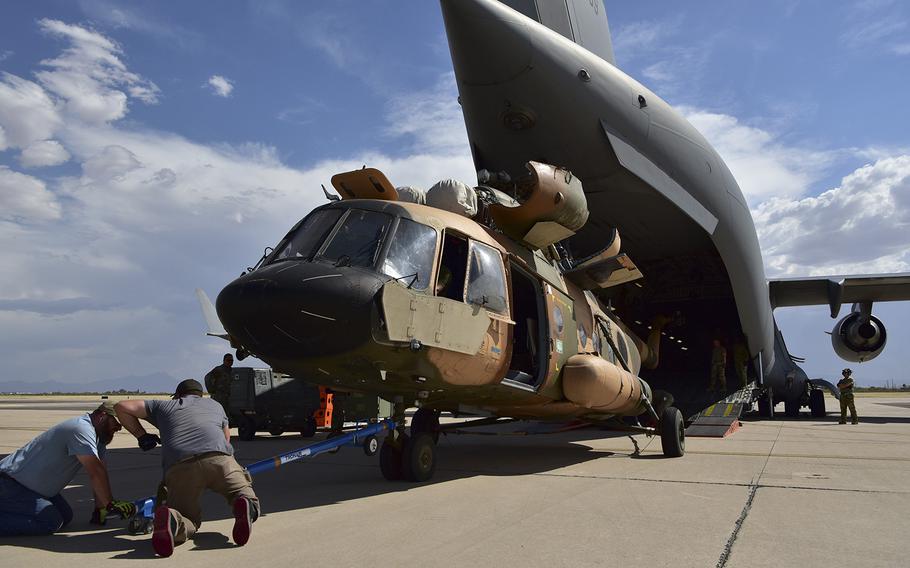 An Mi-17 helicopter is loaded on to a C-17 Globemaster III aircraft at Davis-Monthan Air Force Base, Arizona, on June 9, 2022.