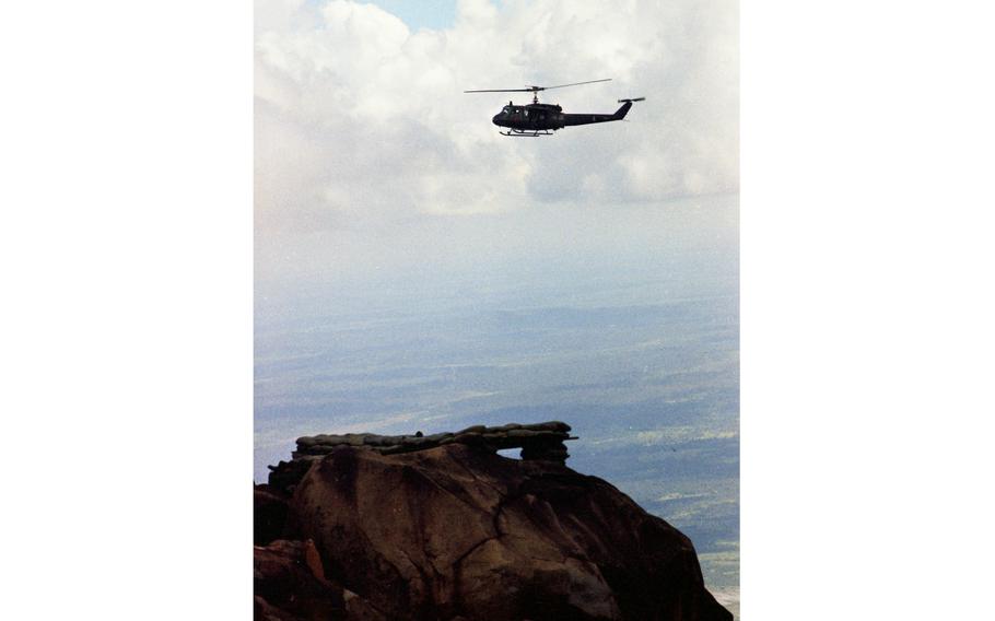 A Huey helicopter approaches one of the three helicopter pads