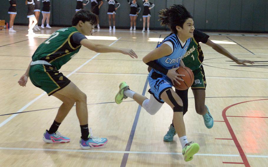 Osan's R.J. Jones drives between Daegu's Beckam Clites and Xavier Brown during Saturday's Korea boys basketball game. The Warriors won 68-61.