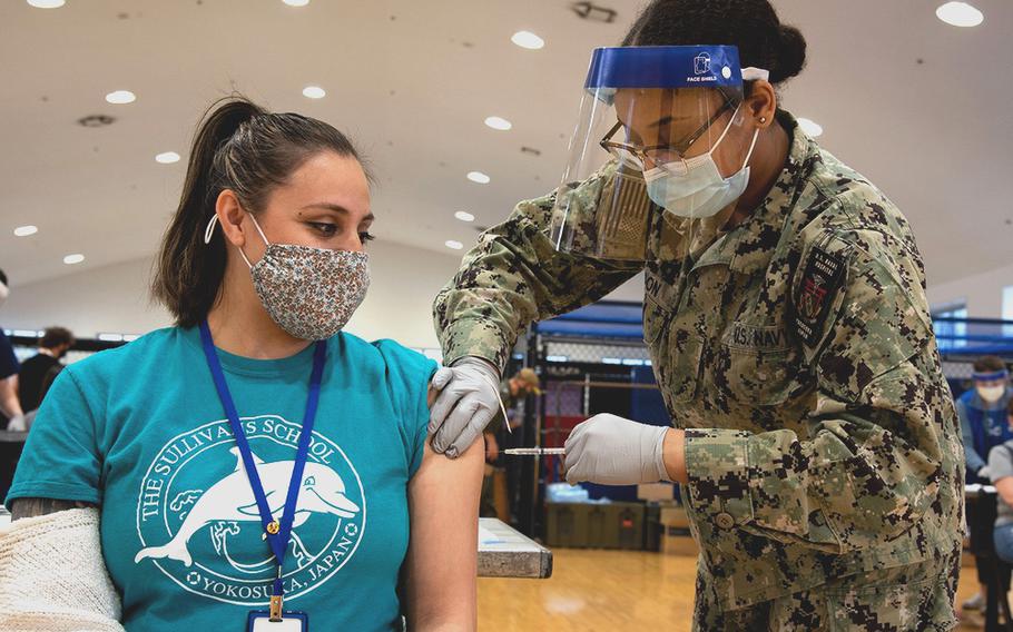 Andrea Hunt, a teacher's aide at Yokosuka Naval Base is vaccinated against COVID-19 byHospital Corpsman Janasia Spotson on March 19, 2021.