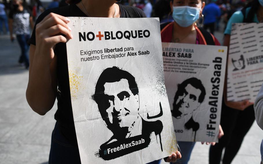 People hold signs with the image of Colombian businessman Alex Saab, who was extradited to the U.S., during a demonstration demanding his release, at the Bolivar square in Caracas, on Oct. 17, 2021. 