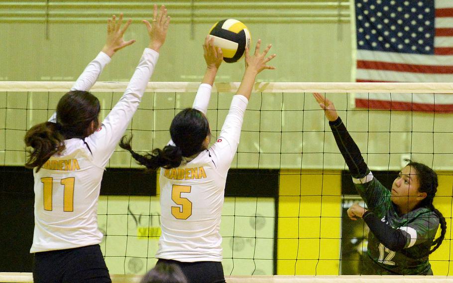 Kubasaki's Ayeli Rocha spikes against Kadena's Leighton Botes and Haide Alvarez during Tuesday's Okinawa volleyball match. The Dragons won in four sets and won the season series 3-1.