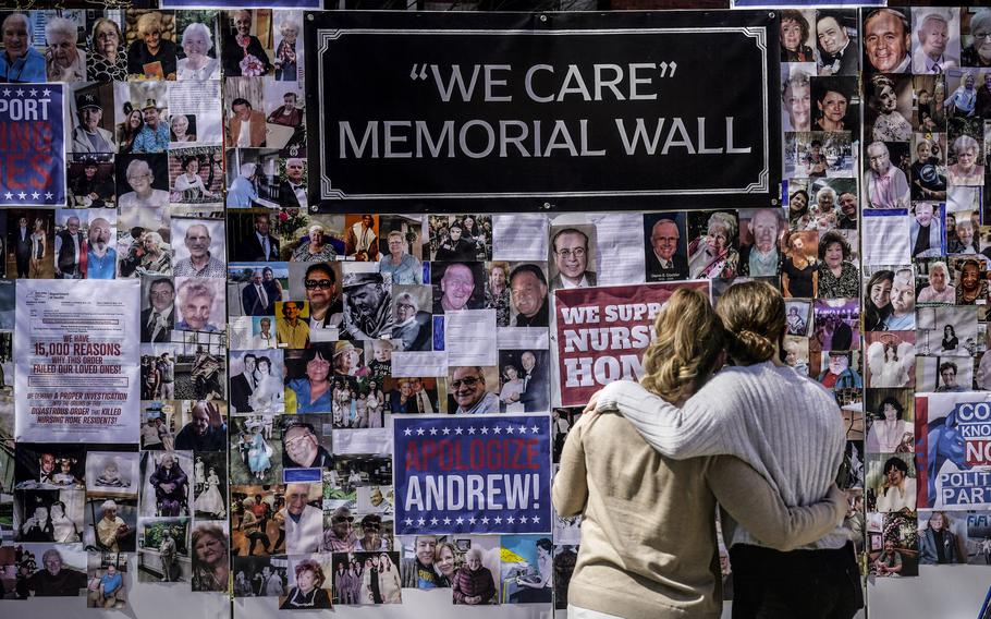 Theresa Sari, left, and her daughter Leila Ali look at a protest-memorial wall for nursing home residents who died from COVID-19, including Sari’s mother Maria Sachse, March 21, 2021, in New York. A state Assembly committee investigation found former New York Gov. Andrew Cuomo’s administration made a political decision to misrepresent how many nursing home residents died of COVID-19.