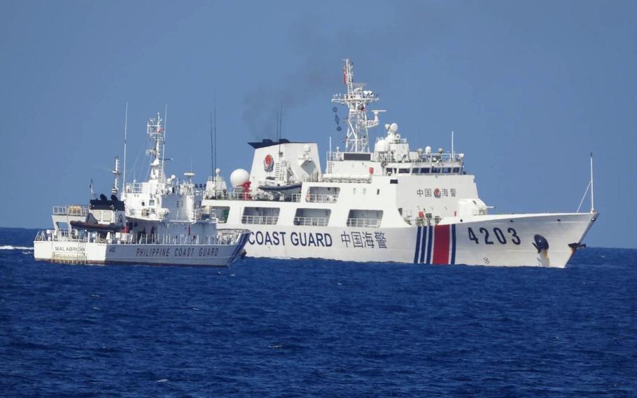 A Chinese coast guard ship blocks a Philippine coast guard vessel in the South China Sea, June 30, 2023.