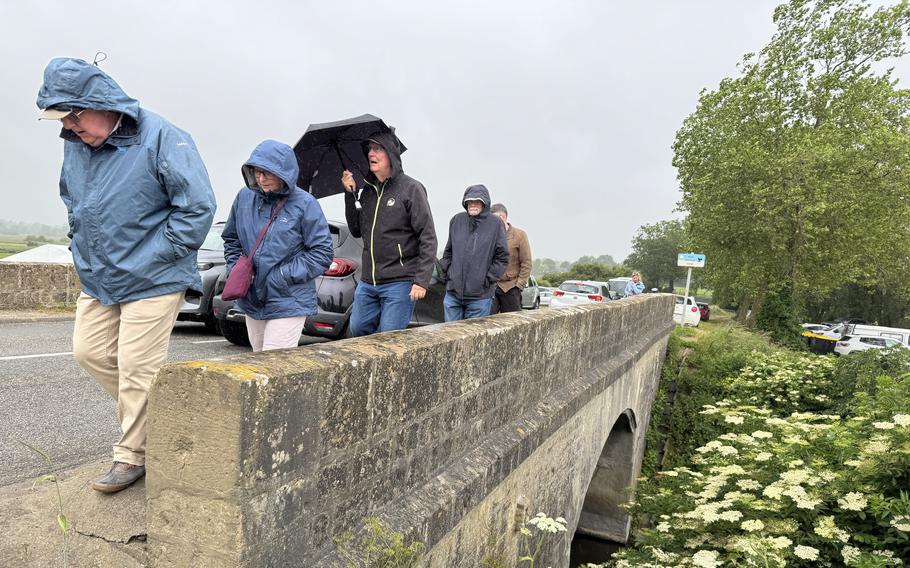 People cross a bridge on a rainy day.