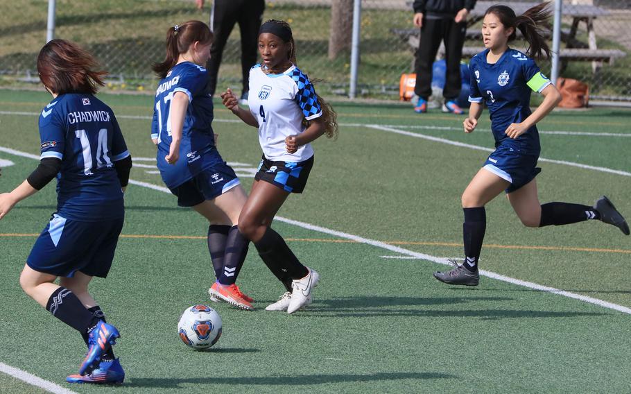 Osan's Tatiana Lunn tries to run down the ball against three Chadwick opponents during Friday's Korea girls soccer match. The Dolphins and Cougars played to a 2-2 draw.