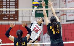 Nile C. Kinnick's Mikaila Joi Miranda spikes between American School In Japan's Aisha Rakyan and Maya Durkee during Tuesday's Kanto Plain volleyball match. The Red Devils won in five sets.