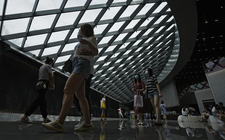 People wearing face masks to help curb the spread of the coronavirus visit a shopping mall in Beijing, China, on June 6, 2021.