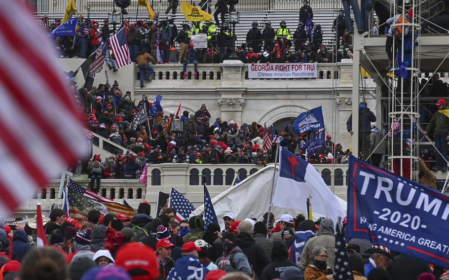 Participants in a mob take over the inaugural stage at the Capitol on Jan. 6. 