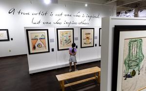 A girl looks at Dalí paintings in a museum. 