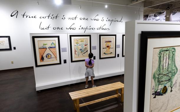A girl looks at Dalí paintings in a museum. 