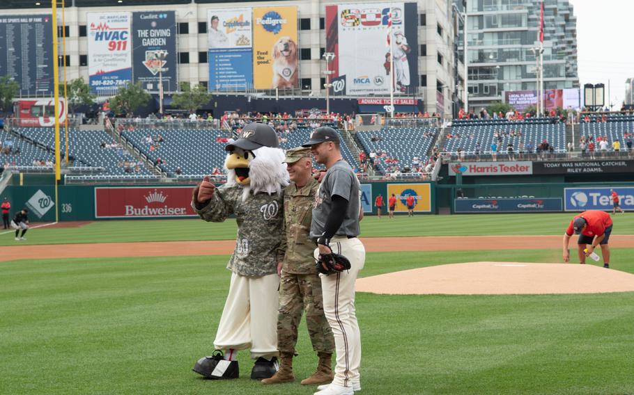 Lt. Gen. John B. Morrison Jr., who threw out the ceremonial first pitch, with the Nationals mascot and catcher Riley Adams during U.S. Army Day at Nationals Park in Washington, D.C., on Friday, June 16, 2023. The Nationals hosted the Miami Marlins.