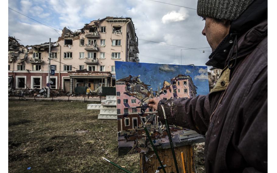 Painter Victor Onishchenko, 43, paints the damaged Hotel Ukraine that was hit by a Russian airstrike in Chernihiv, Ukraine, on April 4, 2022.