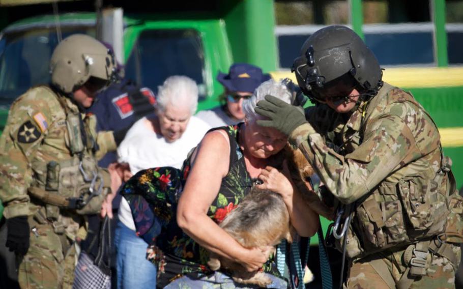 Florida Army National Guard soldiers assist residents of Pine Island Florida evacuate in a CH-47 Chinook on Sept. 30, 2022. The Guard was assisting state and local partners with Hurricane Ian relief.