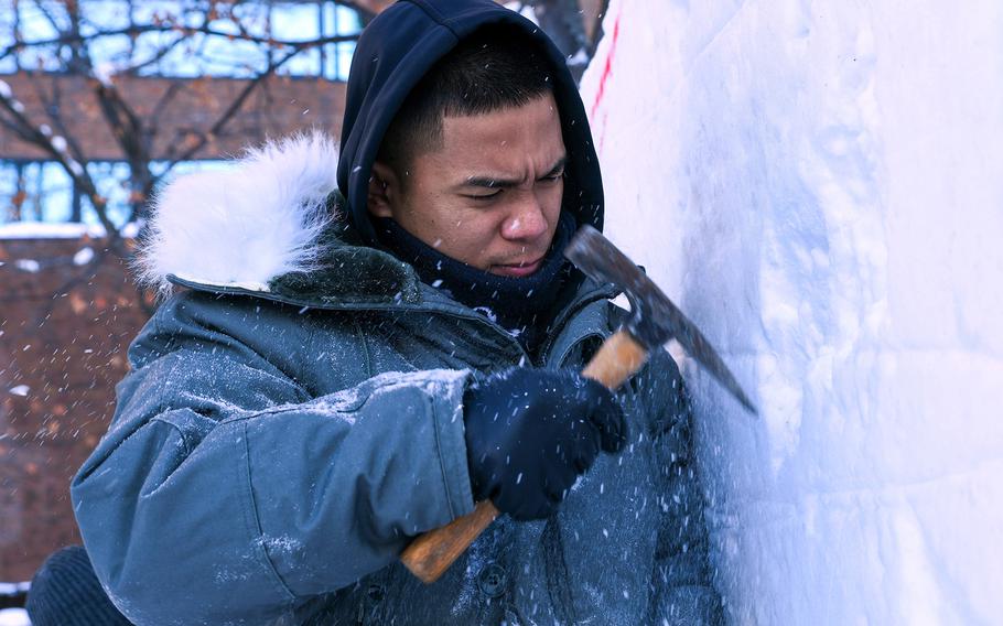 Navy Petty Officer 1st Class Godwin Balderas works on an ice sculpture for the Sapporo Snow Festival in Hokkaido, Japan, Jan. 29, 2023.