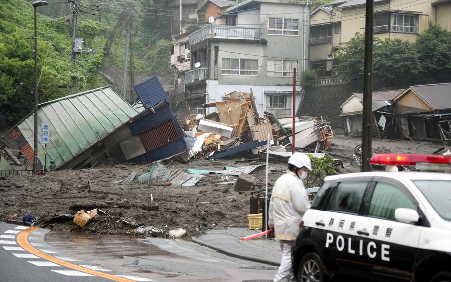 Houses are damaged by mudslide following heavy rain at Izusan district in Atami, west of Tokyo, Saturday, July 3, 2021.