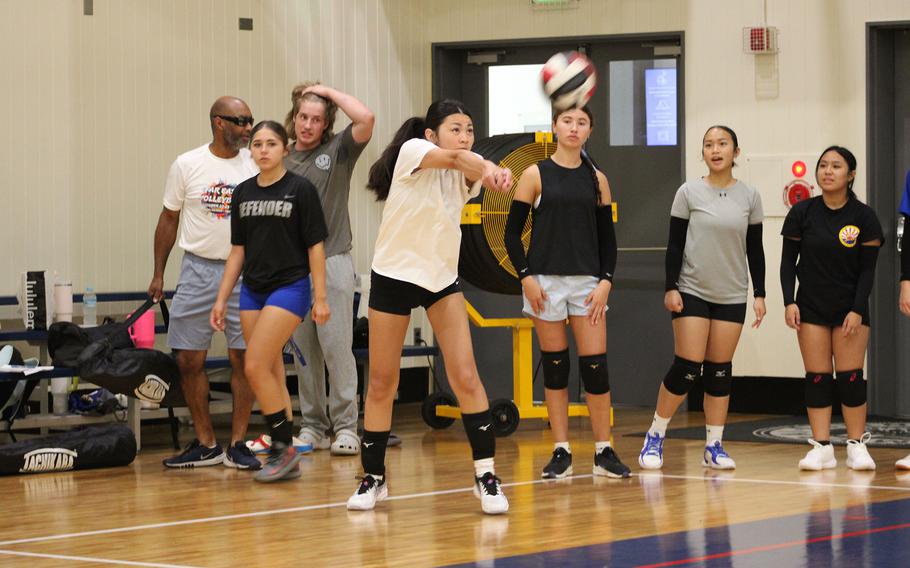 Players return serve in practice.