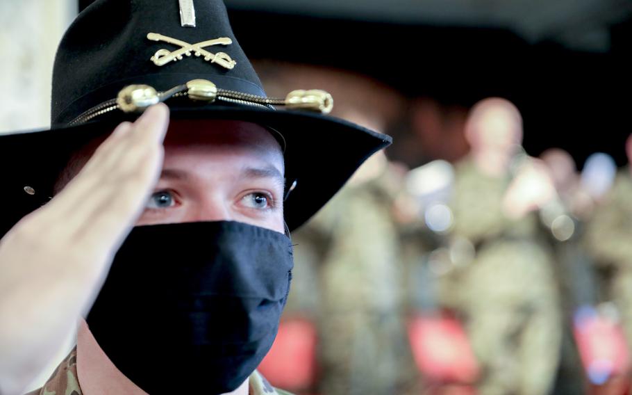 First Lt. Christopher Raymond, 1st Armored Brigade Combat Team, salutes as a Polish army band plays the U.S. national anthem, during the unit's assumption of command ceremony in Zagan, Poland, May 14, 2021. Col. Jon W. Meredith took command of the 1st Cavalry Division brigade at the ceremony.