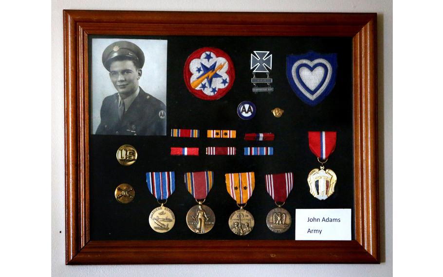 John Adams’s war medals are framed over his chair at his home in Plain Township, Ohio. 