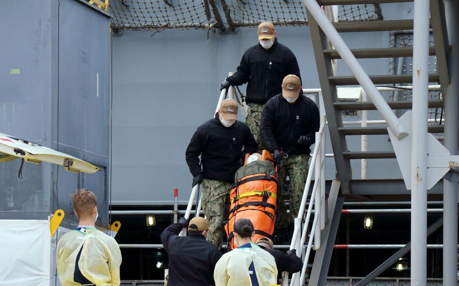 A dummy is carried off the aircraft carrier USS Ronald Reagan during a radiation-leak drill at Yokosuka Naval Base, Japan, Feb. 2, 2023.