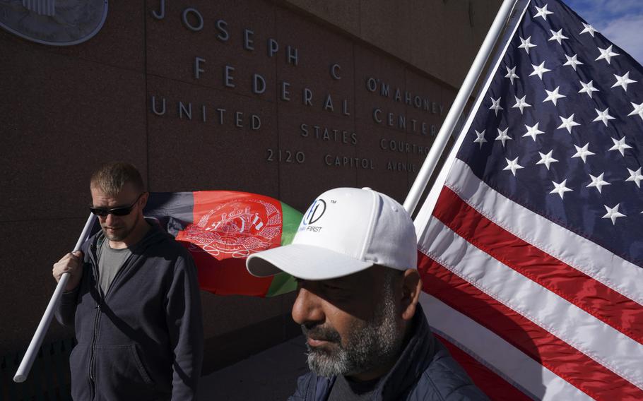 Powers and Rauf carry an Afghan flag and an American flag outside the Cheyenne, Wyo., district offices of Republican Sens. Cynthia M. Lummis and John Barrasso. 