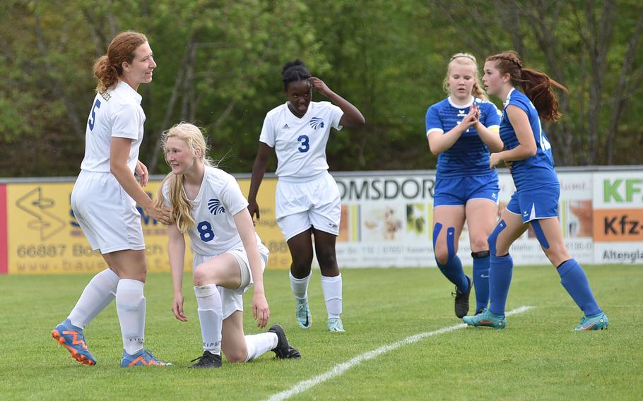 Wiesbaden's Kasey Jacobs, left, helps up teammate Hailey Forrest after the latter missed a chance during a pool-play against Ramstein on May 15, 2023, in Reichenbach-Steegen, Germany. In the middle is the Warriors' Maira Valdez.