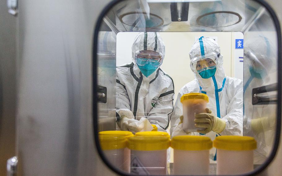 Staff members receive the novel coronavirus strain transported from Zhejiang Provincial Center for Disease Control and Prevention, at a laboratory of Chinese Center for Disease Control and Prevention, in Beijing, capital of China, Feb. 25, 2020. In February of 2023,  China’s flu infections rose while COVID-19 cases continued to drop from a December peak after the nation eased pandemic restrictions. 