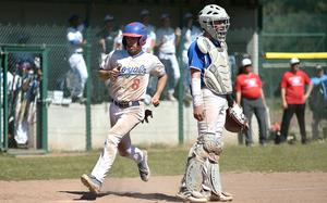 Ramstein's Conor McGinty crosses home plate as Wiesbaden catcher Owen Smith watches his teammates try to get the ball back to the infield during the second game of a doubleheader on April 12, 2025, at Southside Fitness Center on Ramstein Air Base, Germany.