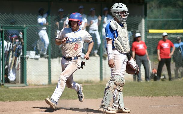 Ramstein's Conor McGinty crosses home plate as Wiesbaden catcher Owen Smith watches his teammates try to get the ball back to the infield during the second game of a doubleheader on April 12, 2025, at Southside Fitness Center on Ramstein Air Base, Germany.