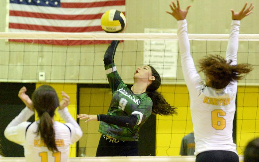 Kubasaki's Olivia Schaffeld spikes between Kadena's Leighton Botes and Jaci Scriven during Tuesday's Okinawa volleyball matach. The Dragons won in five sets to level the season series 1-1.