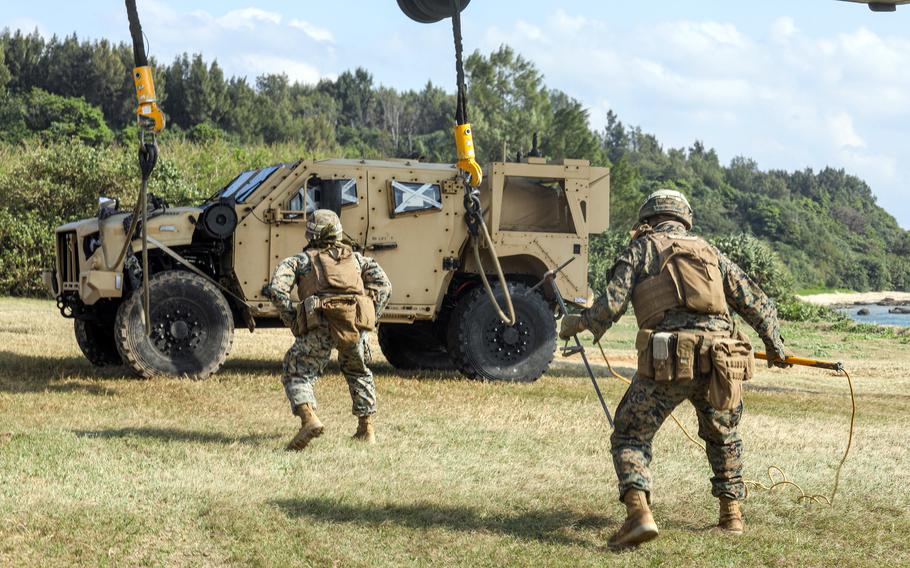 Marines attach a Joint Light Tactical Vehicle to a CH-53E Super Stallion helicopter during a jungle-warfare exercise in Kin Blue, Okinawa, on Feb. 16, 2023.