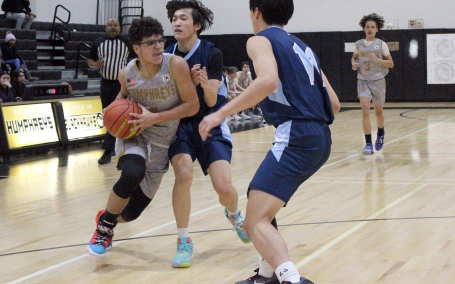 Humphreys' Ryan Gomez drives against Chadwick defenders during Wednesday's Korea boys basketball game. The Blackhawks won 87-62.