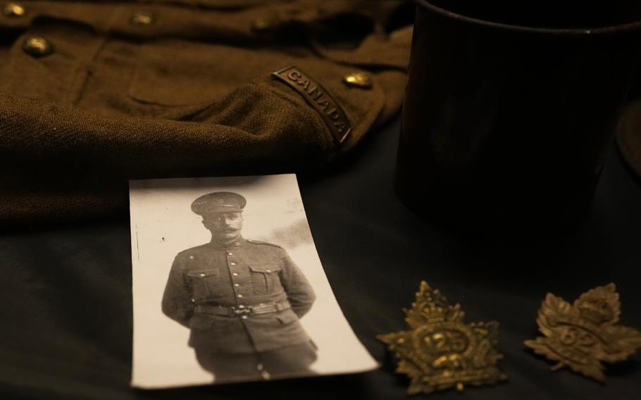 A photo, badge and uniform of a Canadian World War I soldier are on display in a presentation case at Hooge Crater Museum in Ypres on Thursday, Nov. 4, 2021. 