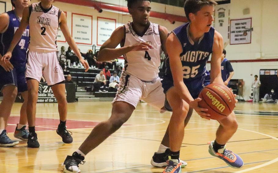 Zama's Ryan Pena guards Christian Academy Japan's Eastin Lowther during Monday's Kanto Plain boys basketball game. The Trojans won 57-33.