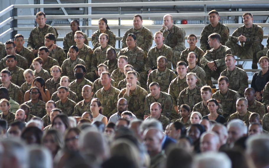 Airmen with the 86th Airlift Wing sit in the bleachers inside a hangar at Ramstein Air Base, Germany, on July 15, 2022, to welcome a new commander. Brig. Gen. Otis C. Jones took command of the wing at a ceremony, taking over from Brig. Gen. Josh M. Olson.