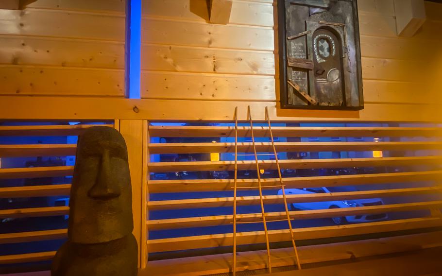 Imitación Moai, una de las estatuas más famosas de la Isla de Pascua, Chile, adorna el interior de la churrasquería Sacramento Chile en Kaiserslautern, Alemania.  Otro aspecto de la decoración es la llamada colección de arte. "Restauracion," La palabra española para un altar. 