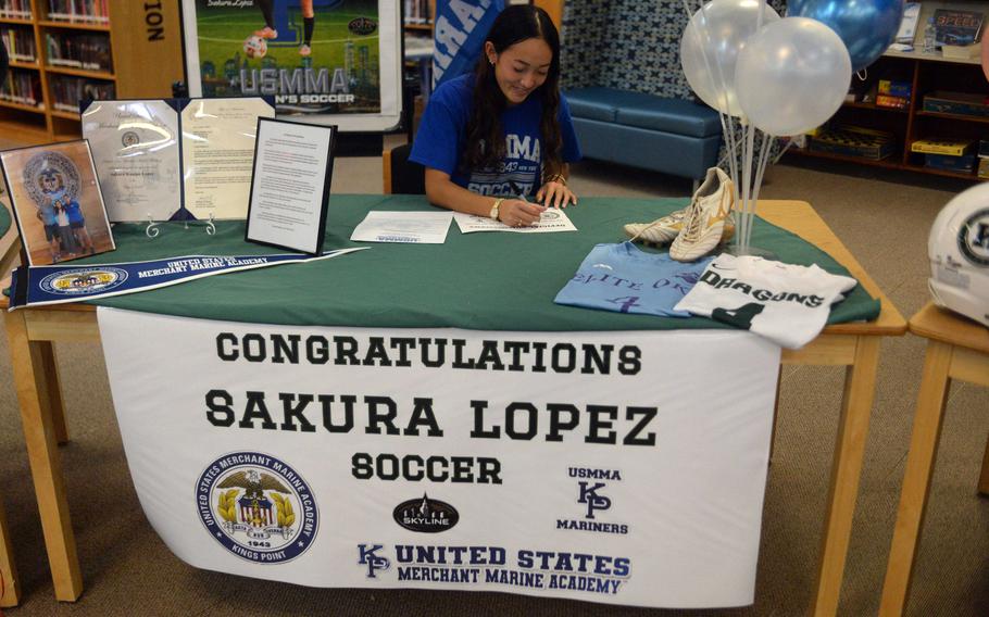 Sakura Lopez signs paperwork.
