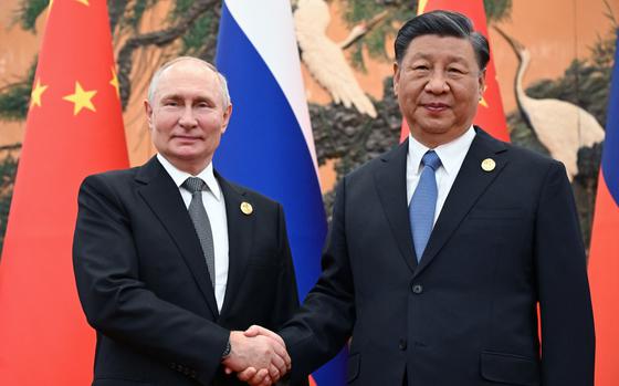 Russian President Vladimir Putin, left, and Chinese President Xi Jinping pose for photos prior to meeting in Beijing in October 2023.