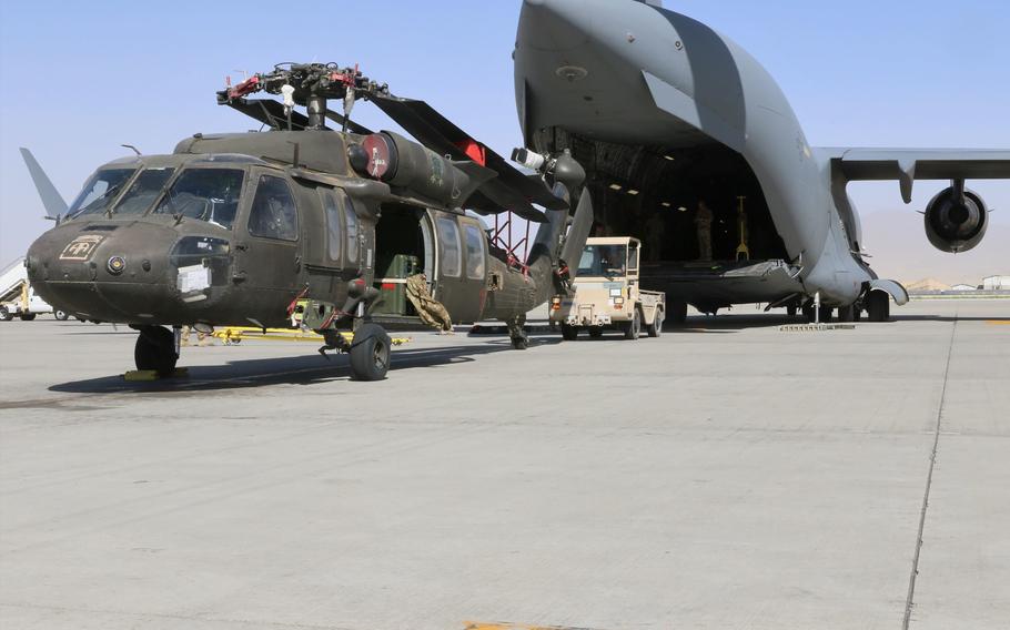 Aerial porters work with maintainers to load a UH-60L Black Hawk helicopter into a C-17 Globemaster III at Bagram Airfield, Afghanistan, as the U.S. military draws down forces and equipment in the country, June 16, 2021.